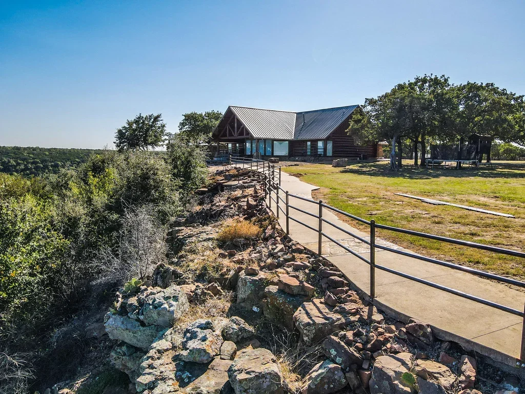 Streambank with rock riprap erosion control, metal ranch fencing, and graded landscape
