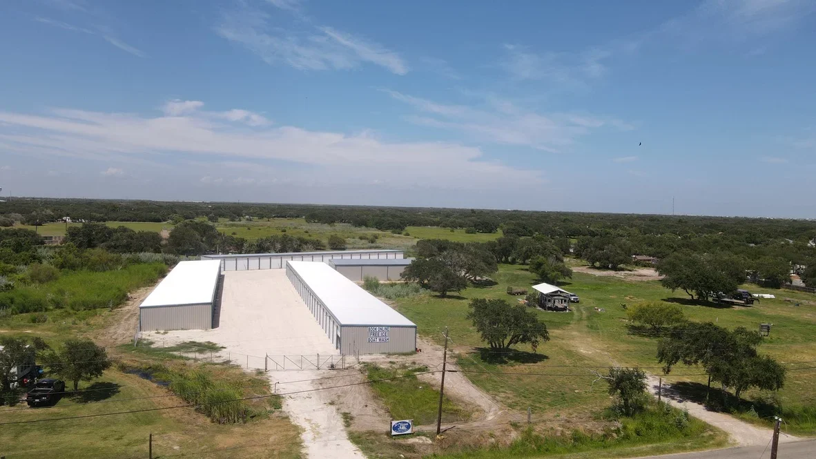 Aerial view of completed metal agricultural building with concrete pad on cleared and graded rural property