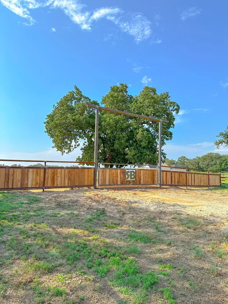 Steel frame ranch gate with wooden panels and metal posts