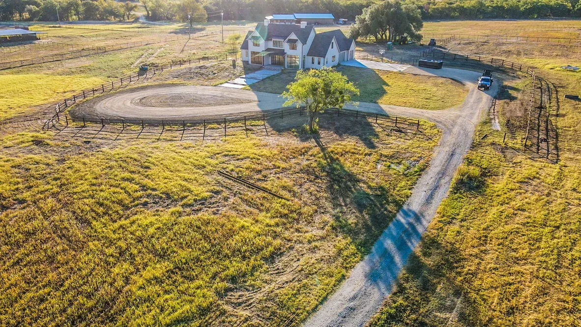 Aerial view of graded driveway and circular pad with gravel base on rural property