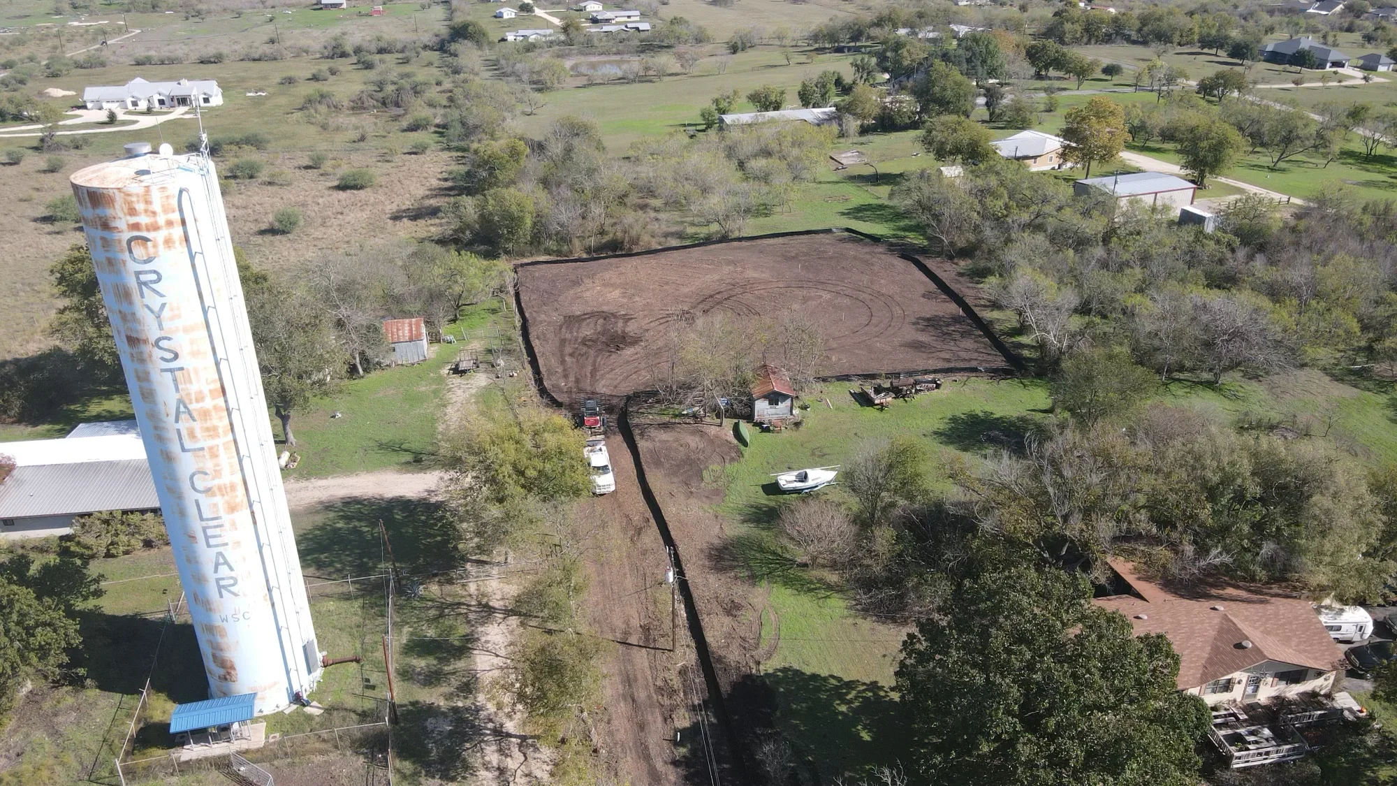 Aerial view of cleared and graded land with black fabric erosion control and equipment on-site